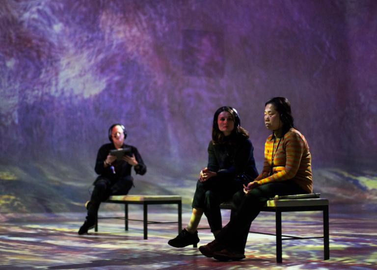 Three people siting in the immersive gallery at FRAMELESS