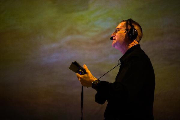 A man wearing headphones in the FRAMELESS immersive gallery and playing the guitar.